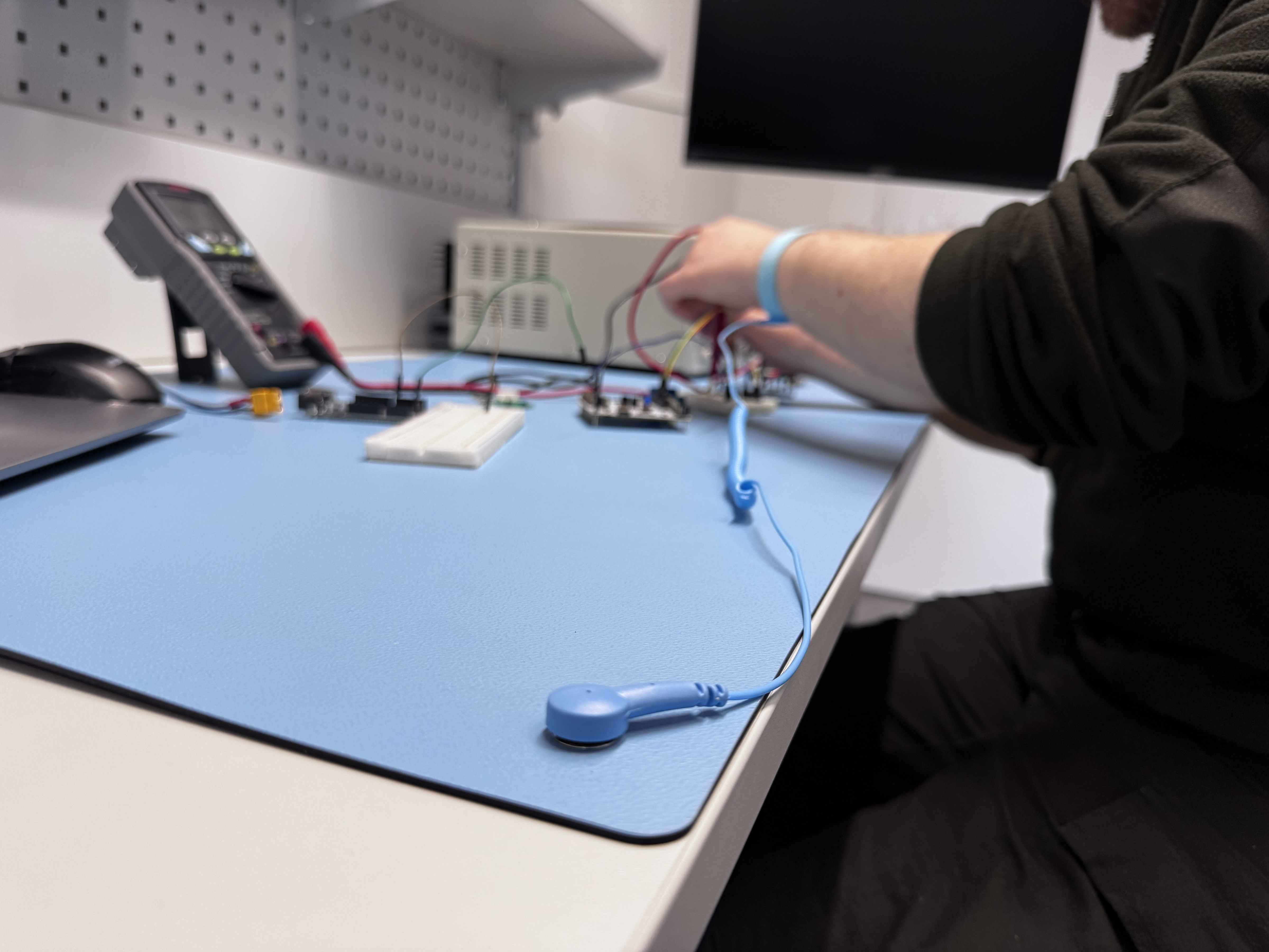 Operator at ESD workbench with wrist strap attached